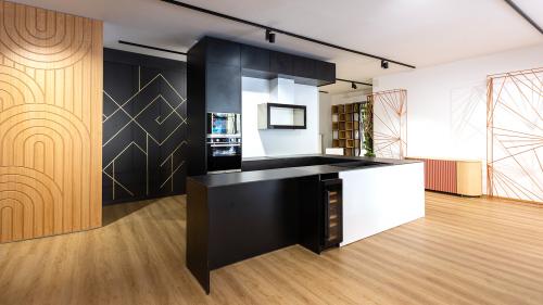 Diese individuell gefertigte Küche verbindet minimalistisches Design mit hoher Funktionalität. Der maßgefertigte Einbauschrank mit goldenen Dekoreinsätzen setzt elegante Akzente und verleiht dem Raum eine exklusive Ausstrahlung.